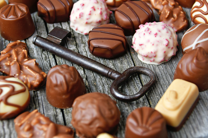 Lots of scrumptious-looking chocolate bonbons surround an old-fashioned metal key. Everything is laid out on a rustic wood board.

I sure hope that this Adonyi Gabor (who took the picture) ate a bunch of chocolates too instead of just playing with them.