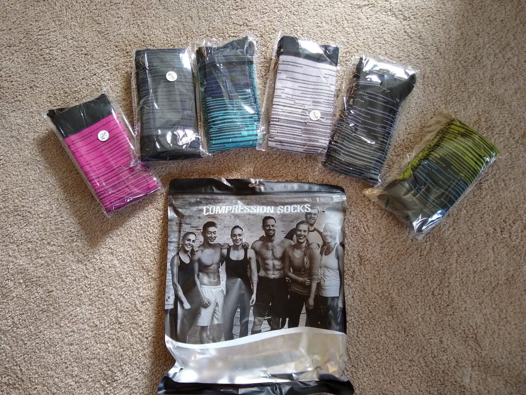 A photo of six pairs of compression socks, arranged around the package.