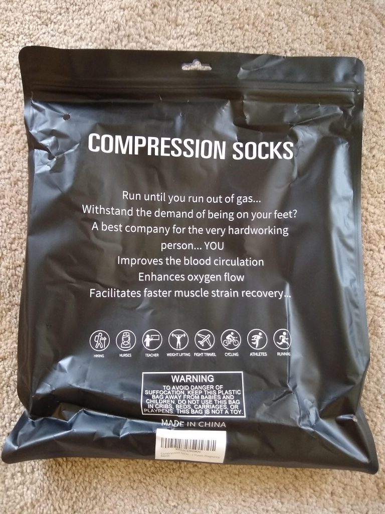 A photo of the back side of the package. It reads, "COMPRESSION SOCKS / Run until you run out of gas... / Withstand the demand of being on your feet? / A best company for the very hardworking / person...YOU / Improves the blood circulation / Enhances oxygen flow / Facilitates faster muscle strain recovery..."