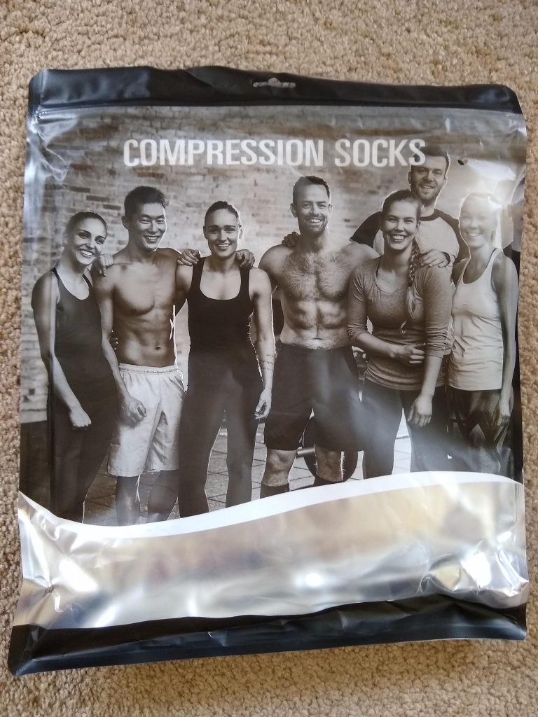 A close-up of the compression socks package. It shows a smiling group of seven, very fit, co-eds. It is not clear if any of them is wearing compression socks.