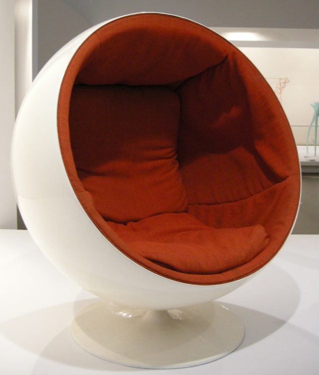 This design-heavy globe chair has half-globe white exterior and a deeply cushioned, comfy-looking orange interior.