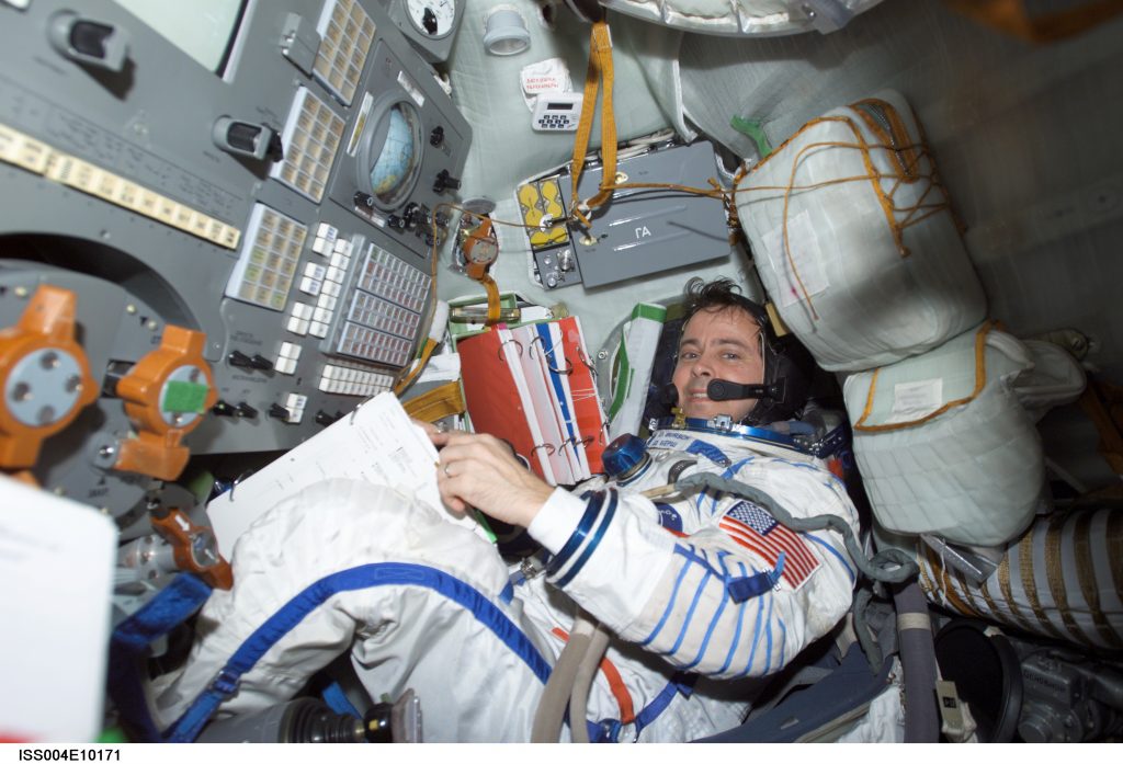 An astronaut sits in the Soyuz 3 capsule while its docked at the International Space Station.