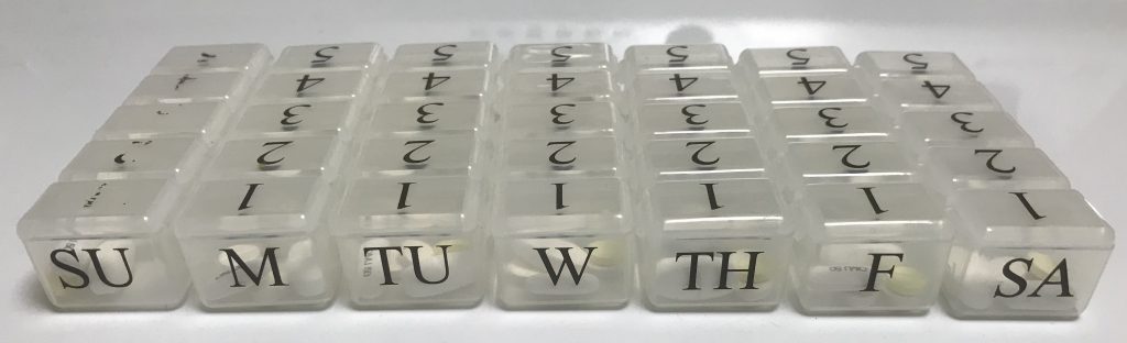 A photo of Claire's pill organizers. Each day gets a row with five separate compartments.