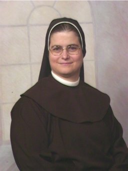 A photo of Maryanne as a sister. She's wearing a black tunic and scapular, a white collar, and a black veil.