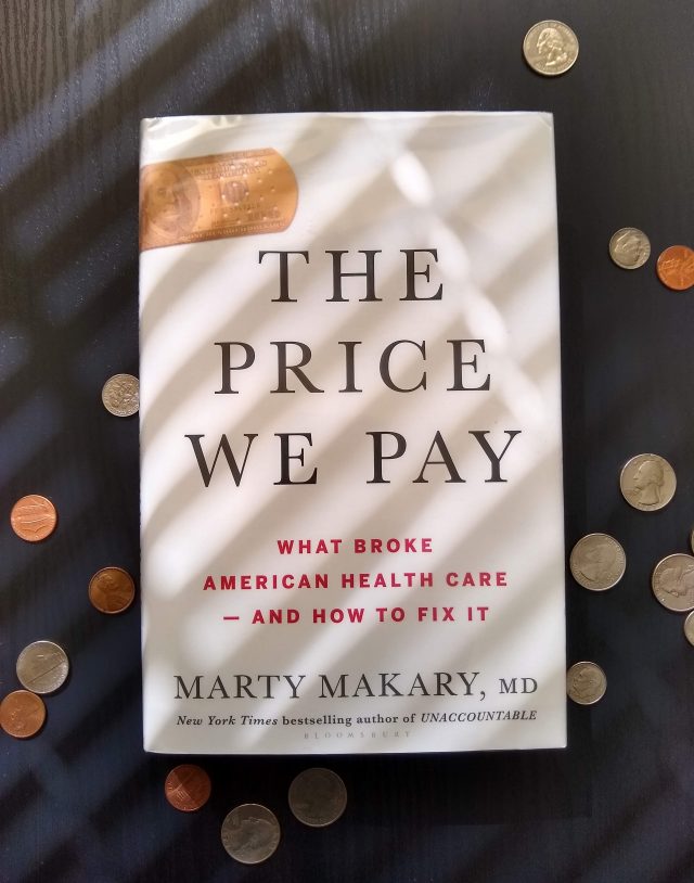 A photo of The Price We Pay: What Broke American Health Care – and How to Fix It by Marty Makary. I set the book on my coffee table, and scattered coins around it. Actually, the coins were already there, I just scattered them to make it look intentional.