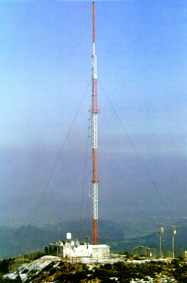 A photo of a freestanding antenna. Guy wires arranged around the antenna add stability.