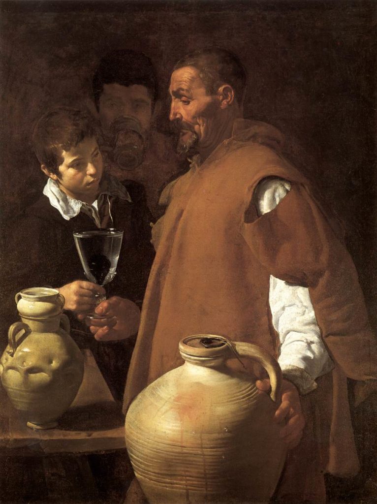 A reproduction of the painting "The Waterseller of Seville" by Diego Velázquez. In the foreground stands the waterseller, a middle-aged man with a short hair and a short beard. He's wearing a brown cloak that's torn to reveal a white shirt underneath. He faces to the left. His left hand rests on a jug of water, while his right hand holds a clear glass of water with a fig in the bottom. His customer, who stands slightly behind and to the left, also has a hand on the glass. The face of a third man is just visible behind the two subjects, This third man appears more as a brown-ish apparition that fades into the brown-ish background than as an actual subject.
