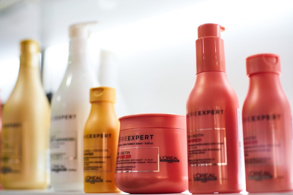 A shelf full of shiny new containers of hair products. The photo is in soft focus, and the labels are not legible.