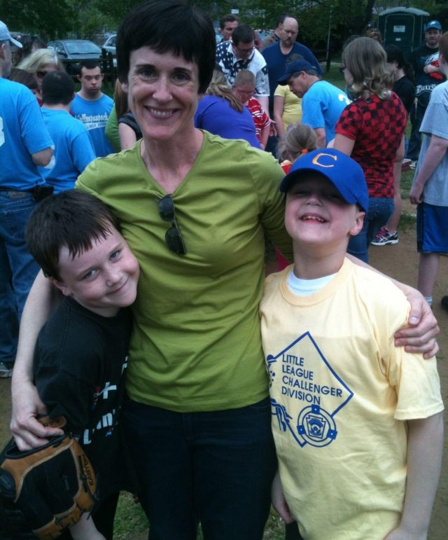 Claire stands with her two boys in front of a crowd of other parents and offspring. This was taken during a special needs baseball game in 2010. Three years later, she'd notice the first symptoms of stiff person syndrome.